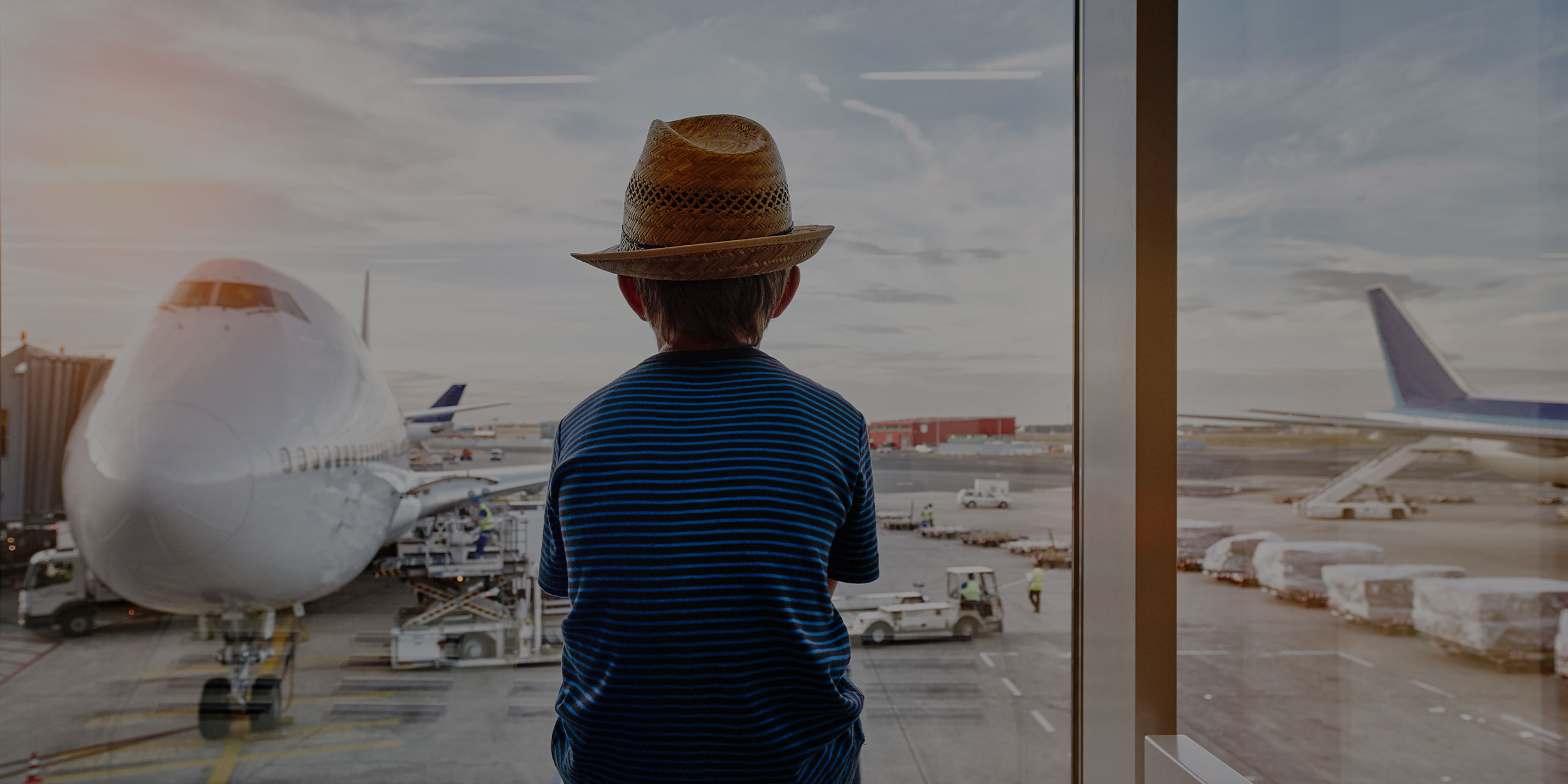 boy looking out the window at airport