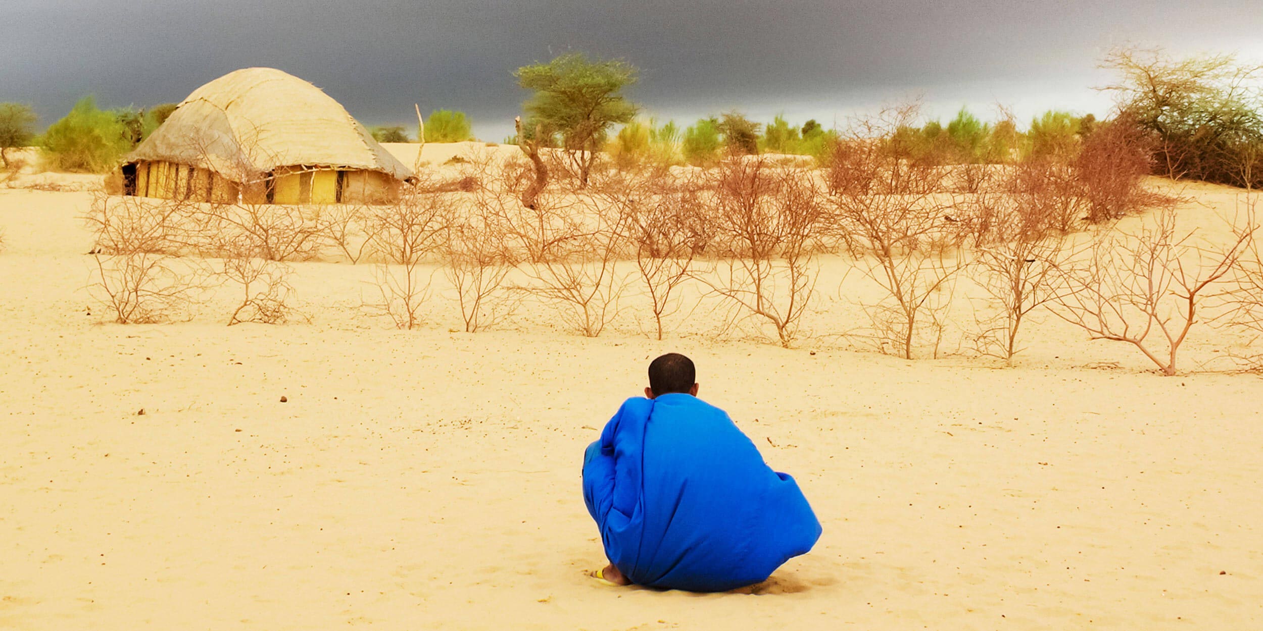 man sitting in desert