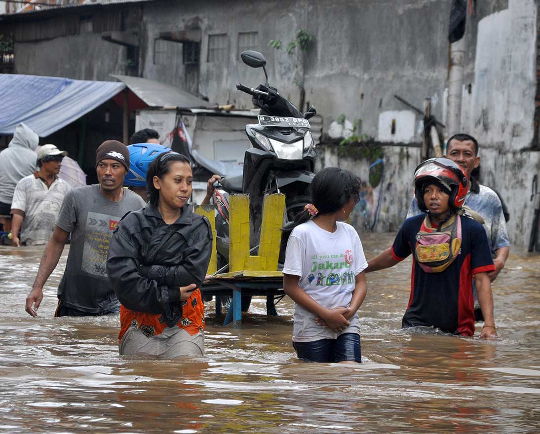 people walking in flooded street
