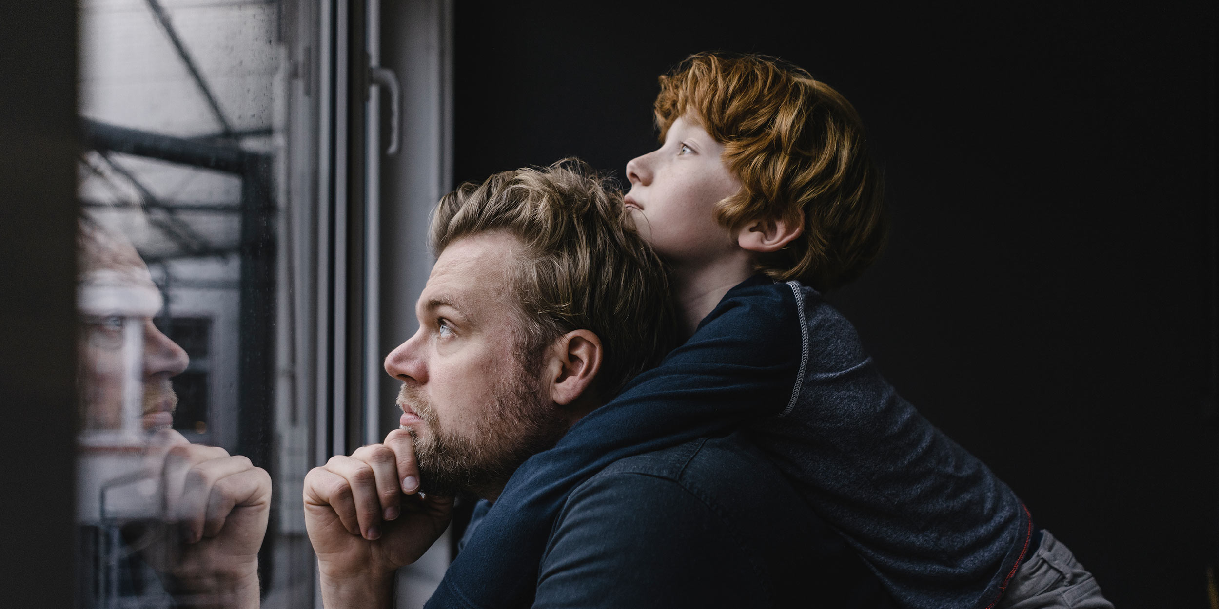 man and boy looking out the window