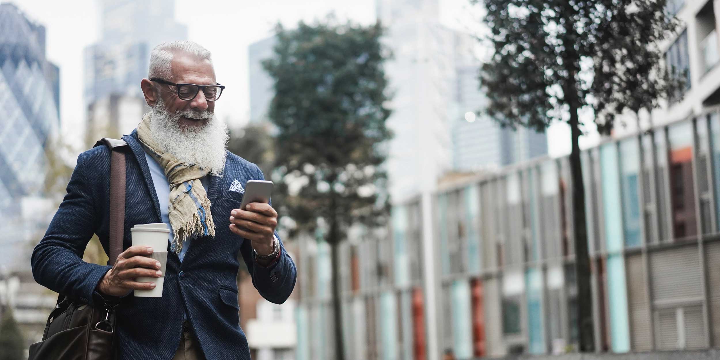 man with coffee looking at phone