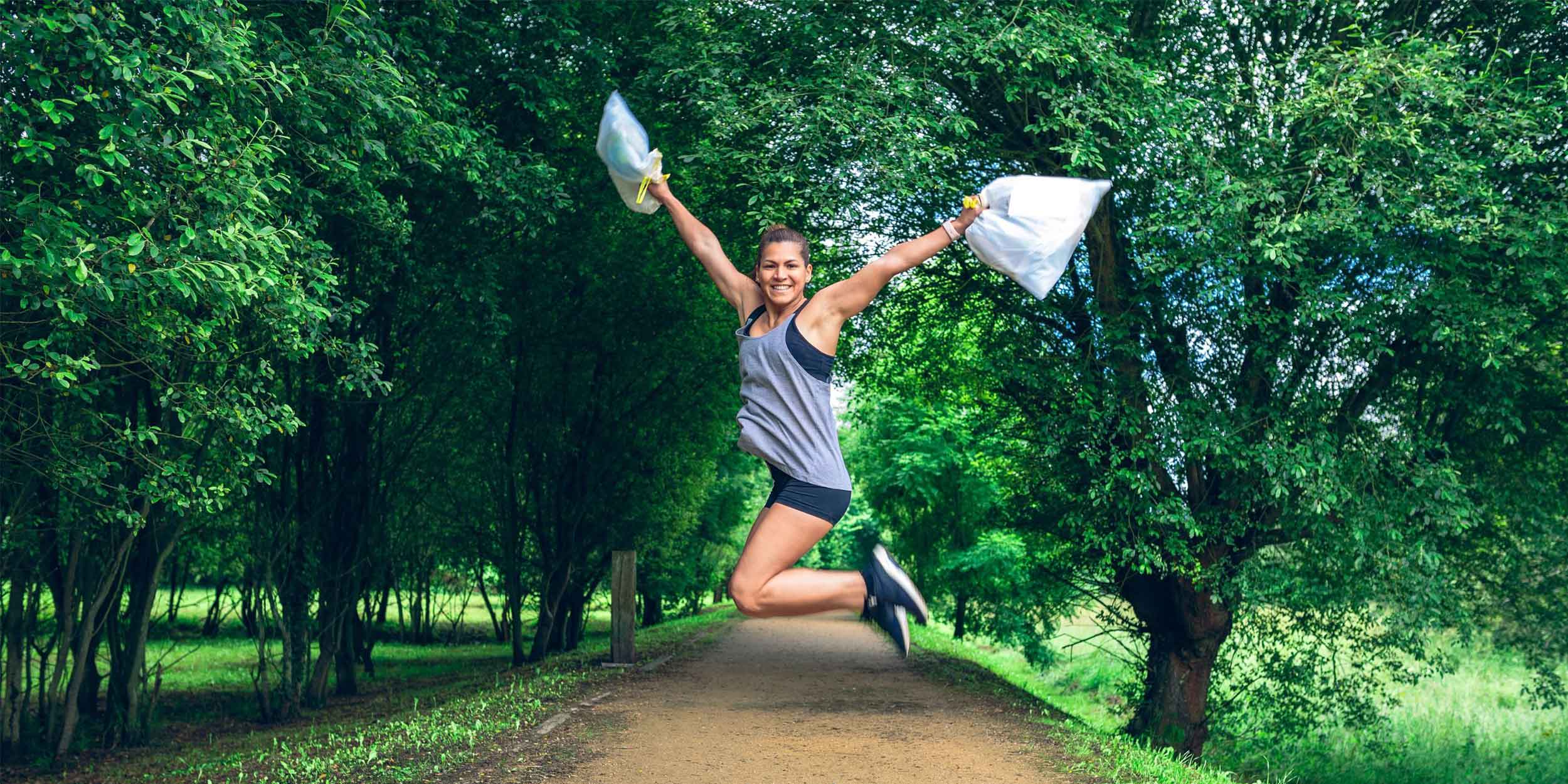 girl jumping with trash bags
