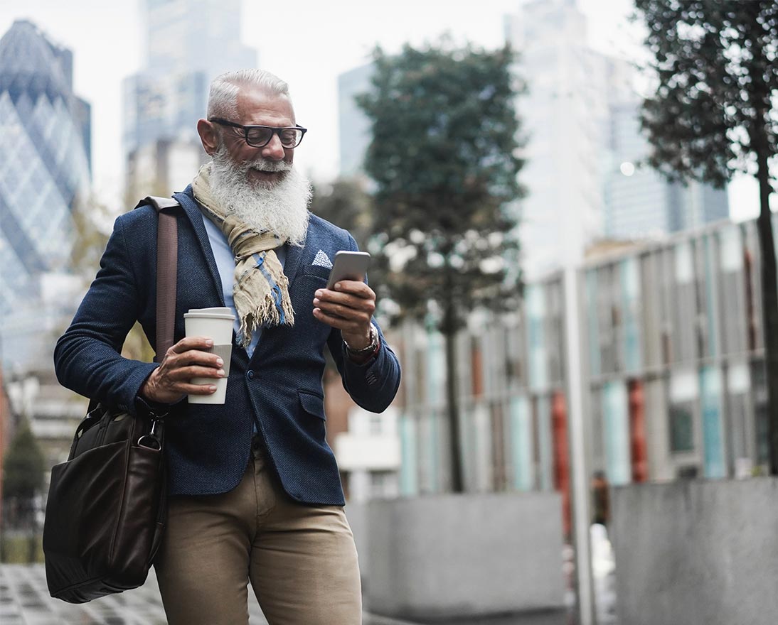 man with coffee looking at phone