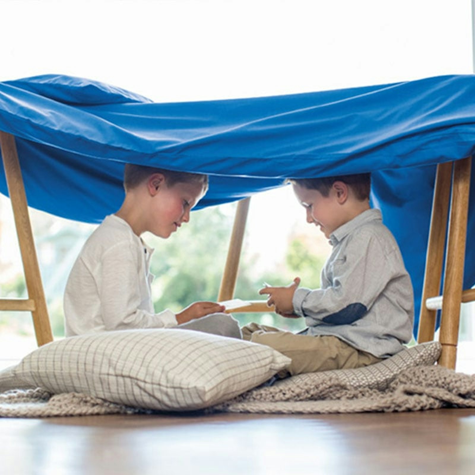 teaser boys playing under blue sheet